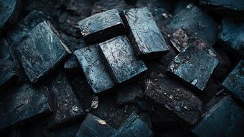 Pile of black rocks with a dark blue background. The rocks are piled on top of each other, creating a sense of depth and texture. Scene is somber and mysterious, as the dark colors photo