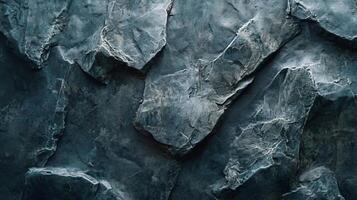 Close up of a rock wall with a blue and gray color scheme. The wall is made up of many different sized rocks, giving it a rugged and natural appearance. Scene is one of strength and resilience photo