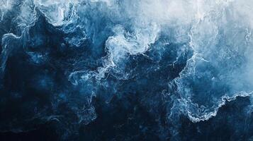 The image is of a large body of water with a lot of waves. The water is a deep blue color, and the waves are crashing against the shore photo