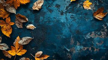 Blue background with a bunch of yellow leaves scattered around it. The leaves are of different sizes and shapes, and they are arranged in a way that creates a sense of depth and movement photo