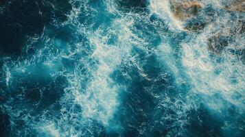 The image is of a body of water with waves crashing against the shore. The water is a deep blue color, and the waves are white and choppy photo