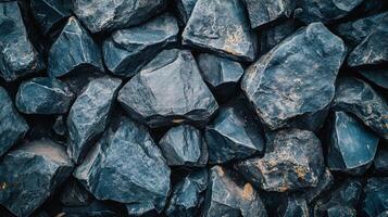 Pile of rocks with a blue hue. The rocks are piled up and appear to be rough and jagged. The image has a rugged and natural feel to it photo