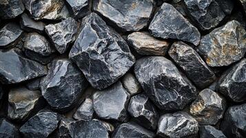 Close up of a wall made of large rocks. The wall is made of many different sized rocks, some of which are large and some of which are small photo