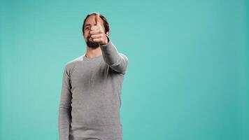 Portrait of upbeat man showing thumbs up sign gesturing, exulting happy facial expression and satisfaction. Jolly Arab person being excited, doing approving hand gesture, studio background, camera B video