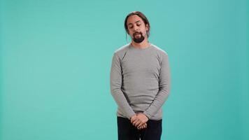 Portrait of bored man lacking enthusiasm to do anything, yawning, wasting time, isolated over studio background. Lazy person living monotonous life, having sleepy dull facial expression, camera A video