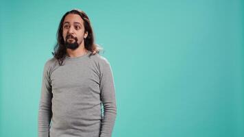 Portrait of spiteful man making exaggerated silly faces, mimicking someone, doing mocking gesturing. Person making goofy facial expressions, being playful, making fun, studio background, camera B video