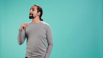 Cheerful man acting casually, exuding nonchalant and carefree demeanor. Portrait of jolly person being relaxed and at ease, showing self assuredness, studio background, camera B video