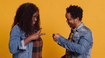 Cheerful positive married couple playing rock paper scissors in studio, having fun with a children activity and competition. Playful joyful man and woman trying to make a decision. Camera A. video