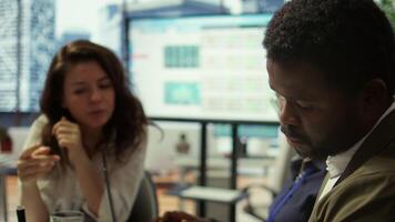 Important business investor studying development progress reports on tablet, examining big data visualization tools during a briefing meeting with executive board members. Management. Camera B. video