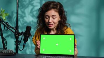 Online show host being sponsored by partnering brand to do isolated screen laptop unboxing content. Tech expert does influencer marketing, doing chroma key notebook product placement, camera A video