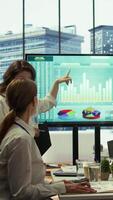 Vertical PR team presenting infographics and digital marketing insights for growth, showcasing the impact of recent campaigns and outlining plans for future development initiatives in workspace. Camera B. video