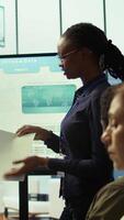 Vertical In a high end boardroom, employees gather to brainstorm ideas and create strategies, analyzing statistics to drive business development and ensure successful project. Enterprise solutions. Camera B. video