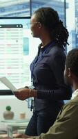 Vertical Employees team analyzing infographics to offer solutions for new project, looking to finish tasks before deadline. Enterprise coworkers attending problem solving conference in boardroom. Camera A. video