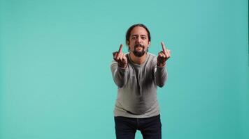Irked man fighting with friend, doing middle finger sign gesturing, isolated over studio background. Outraged person arguing during conversation, doing obscene hand gestures, camera A video