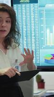 Vertical Coworkers engaging in a problem solving meeting at a corporation, using an interactive board to visualize data and develop solutions for complex business challenges. Analysis presentation. Camera A. video