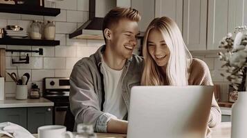 A man and woman are sitting at a table in front of a laptop photo