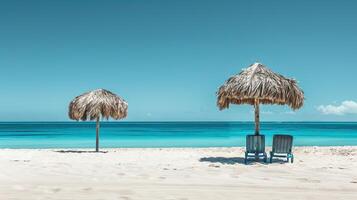 Two chairs and a thatched umbrella on a beach photo