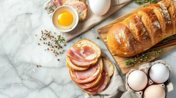 Bread, eggs, ham and herbs on a marble countertop photo