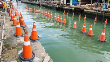 A row of orange cones in the water photo