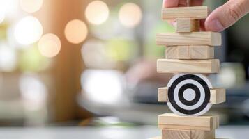 A person holding wooden blocks with a target on top photo