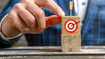 A man in a suit is holding a wooden block with a target on it photo