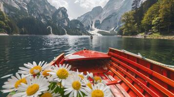 A boat with daisies on the side of a mountain lake photo