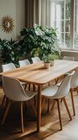 A dining table with white chairs and a plant photo
