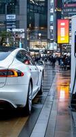 A white tesla car is parked at an electric charging station photo