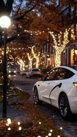 A white tesla car is parked on a street with christmas lights photo