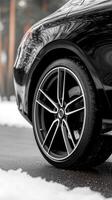 A black car with a tire on the road photo