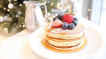 A stack of pancakes with berries and syrup on top photo