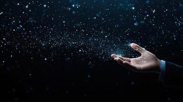 A hand reaching out to the sky with snow falling photo