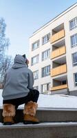 A person sitting on the steps of a building photo