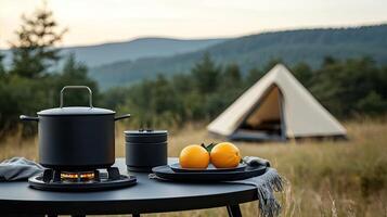 A camp stove, a pot, and a plate with oranges on it photo