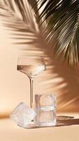 Ice cubes and a glass of wine sit on a tan background photo