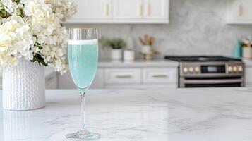 A blue glass of champagne on a marble counter photo