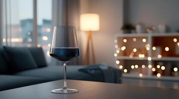 A glass of wine sitting on a table in front of a couch photo