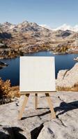 An easel with a blank canvas on top of a mountain photo