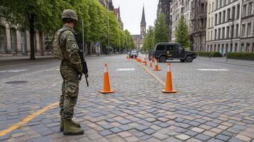 A soldier stands guard on a street in front of a building photo