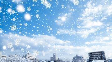 Snowflakes falling on a blue sky with buildings in the background photo