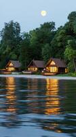 The moon rises over the water and the cottages photo
