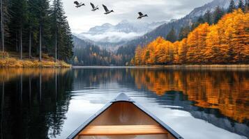 A canoe is floating on the water in front of a mountain photo