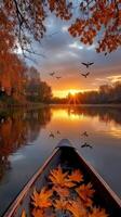 A canoe is on the water with leaves and birds flying over it photo