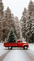 A red truck driving down a snowy road with a christmas tree in the back photo