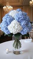 A vase filled with blue and white flowers on a table photo