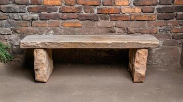 A stone bench sitting in front of a brick wall photo