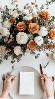 Wedding table setting with white tablecloth and flowers photo