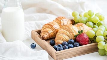 Croissants, grapes, and milk on a tray photo