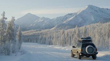 A car driving down a snowy road with mountains in the background photo