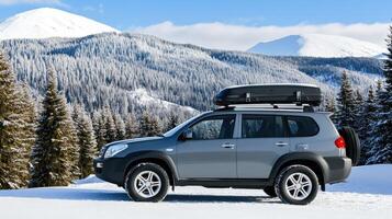 A silver suv with a roof rack on top of it in the snow photo